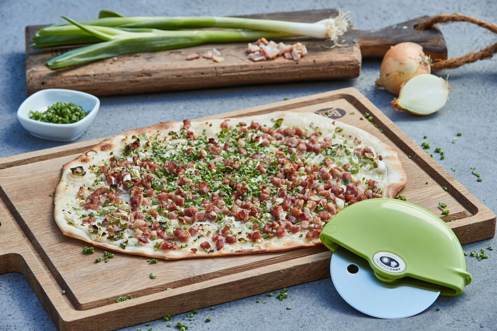 Outdoorchef Pizzaschneider beim Servieren einer Pizza